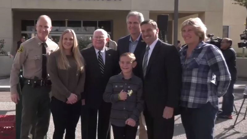 Sheriff's Captain and people standing next to building
